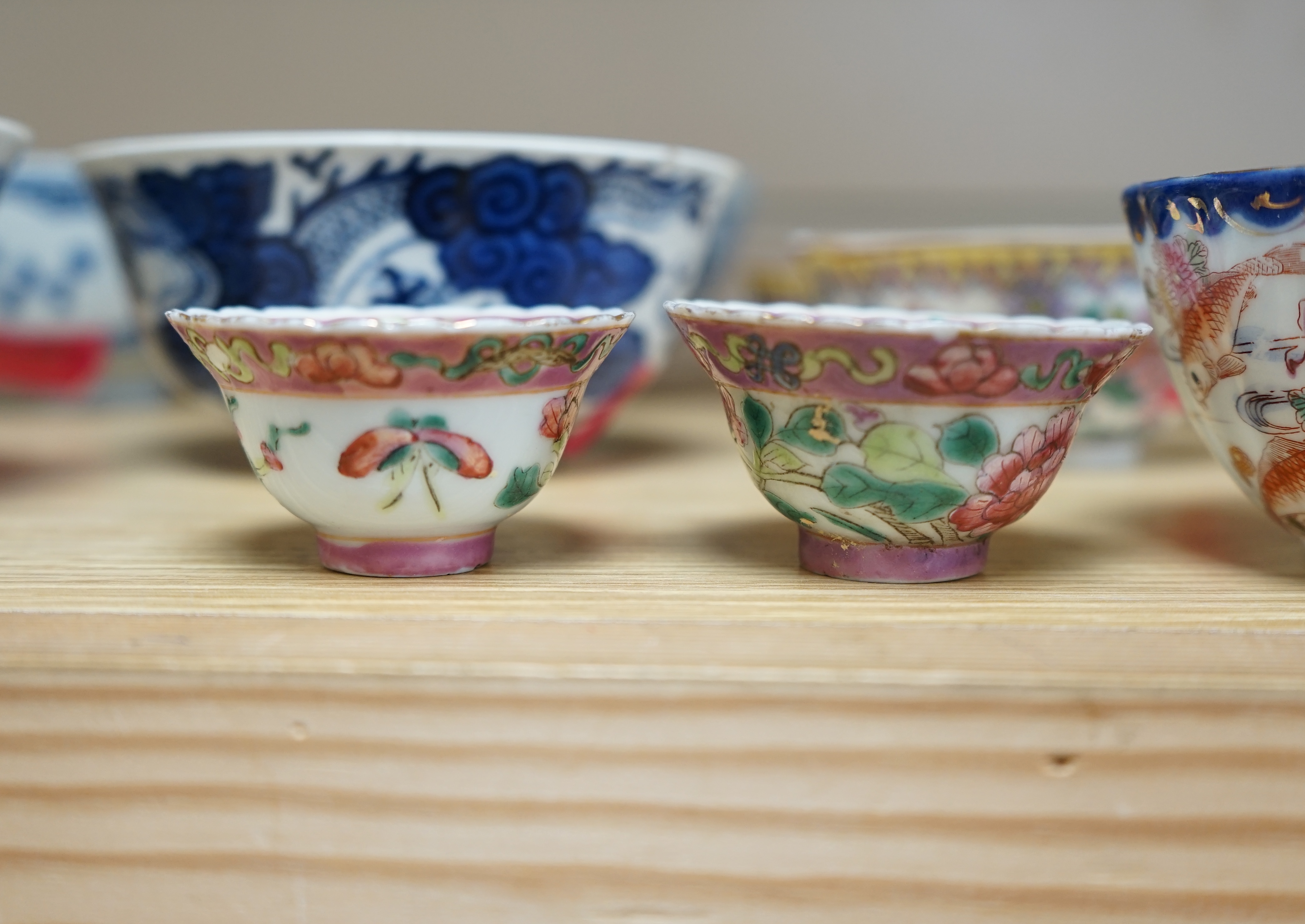 A quantity of Chinese and Japanese porcelain to include blue and white bowls, famille rose tea bowls and a pair of late 19th century dishes (18). Condition - varies, poor to fair